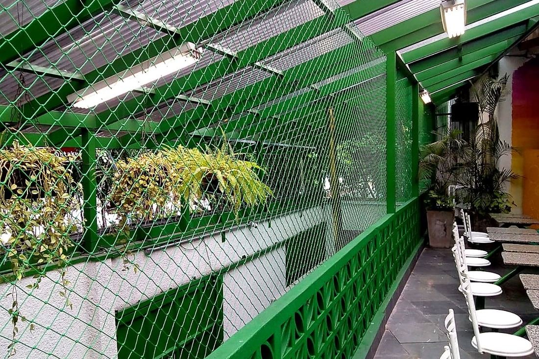 Área gourmet coberta com rede de proteção verde